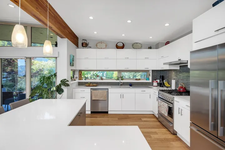 Kitchen with stainless steel appliances, decorative backsplash, recessed lighting, light wood finished floors, and decorative light fixtures