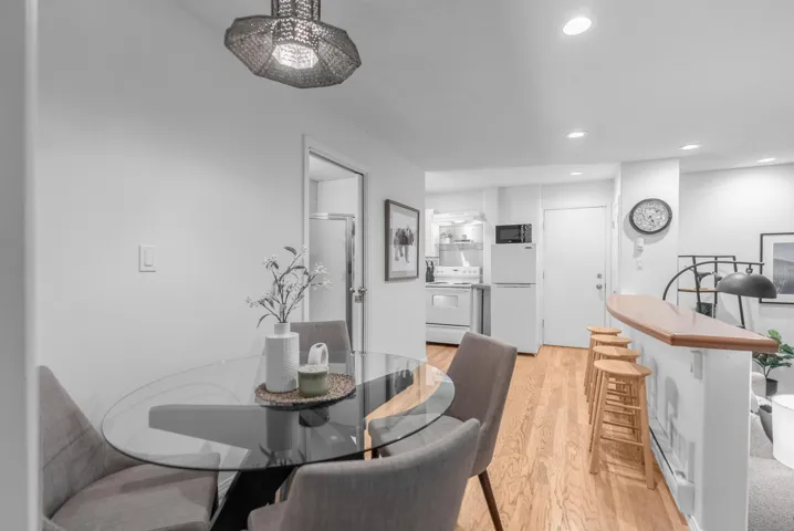 Dining space with light wood-style flooring, recessed lighting, and a baseboard heating unit