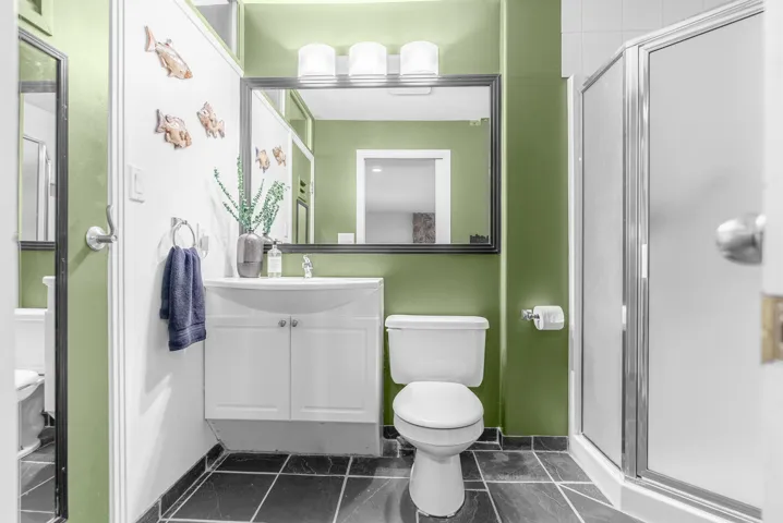 Bathroom featuring vanity, a shower stall, and dark tile patterned flooring
