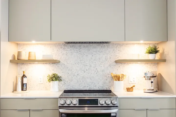 Kitchen with open shelves, tasteful backsplash, gray cabinetry, and stainless steel electric stove