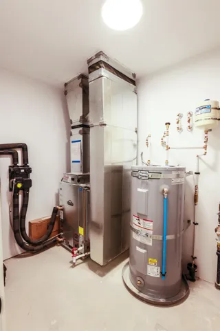 Utility room featuring heating unit and water heater