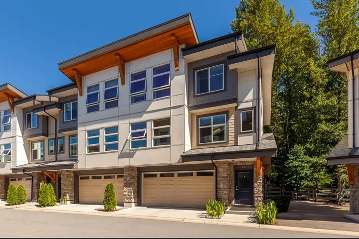 View of front of property with an attached garage, stone siding, a residential view, and stucco siding