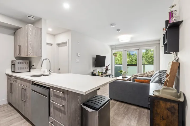 Kitchen featuring open floor plan, a sink, a peninsula, light wood-type flooring, and recessed lighting