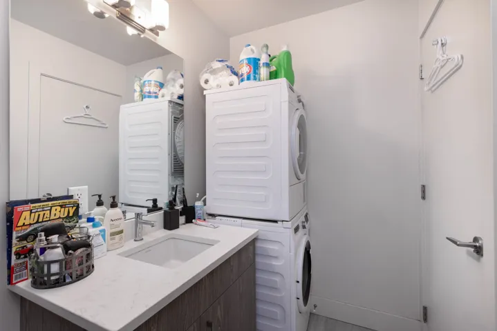 Clothes washing area featuring stacked washer / dryer