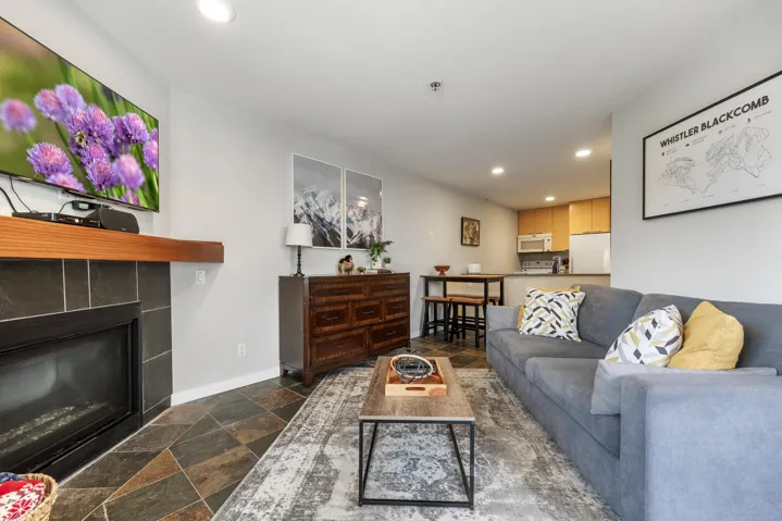 Living area featuring recessed lighting, stone tile flooring, and a tiled fireplace