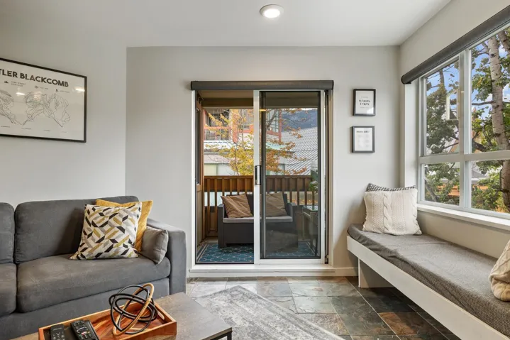 Living area with healthy amount of natural light, stone tile flooring, and recessed lighting