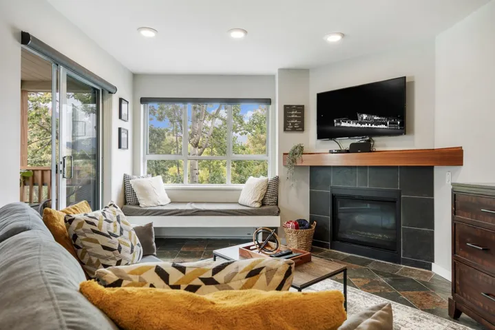 Living area featuring stone tile floors, a fireplace, healthy amount of natural light, and recessed lighting