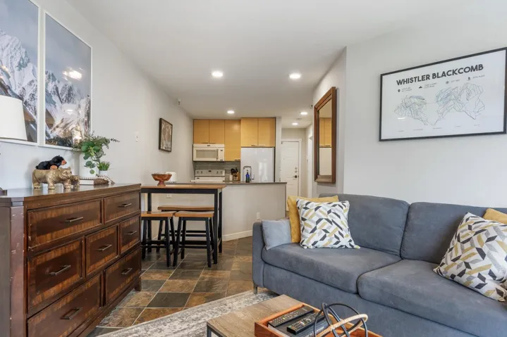 Living area with recessed lighting and dark stone finish flooring