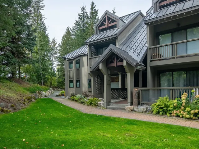 Rear view of property featuring a lawn, a standing seam roof, and metal roof