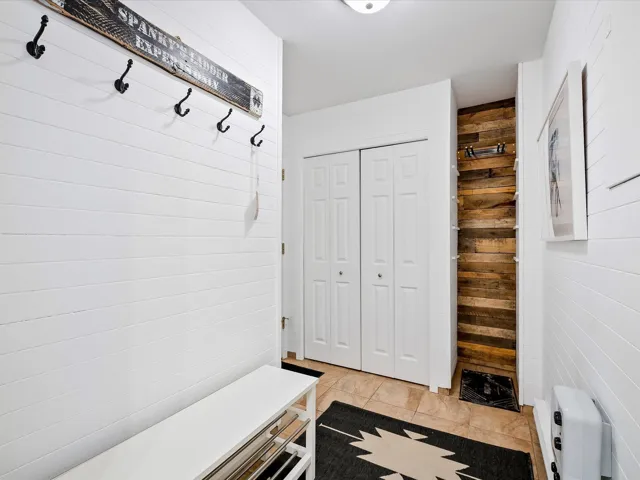 Mudroom featuring wood walls
