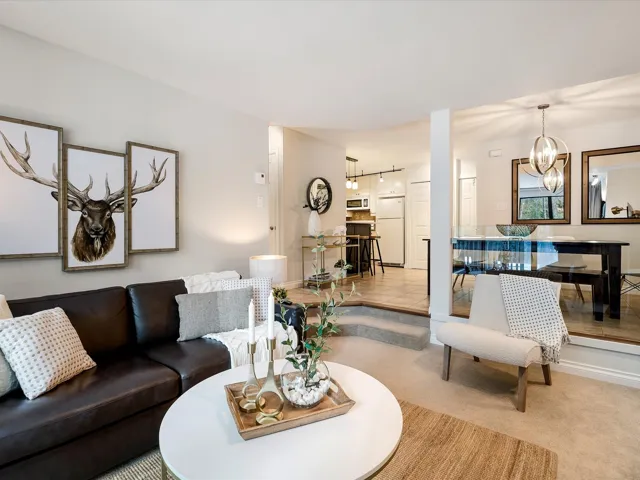 Living area featuring carpet floors and a notable chandelier