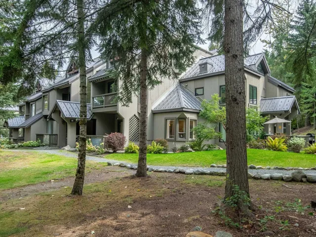 View of front of property featuring stucco siding, a front yard, a standing seam roof, and metal roof