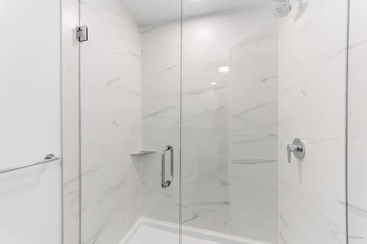 Full bathroom with a marble finish shower