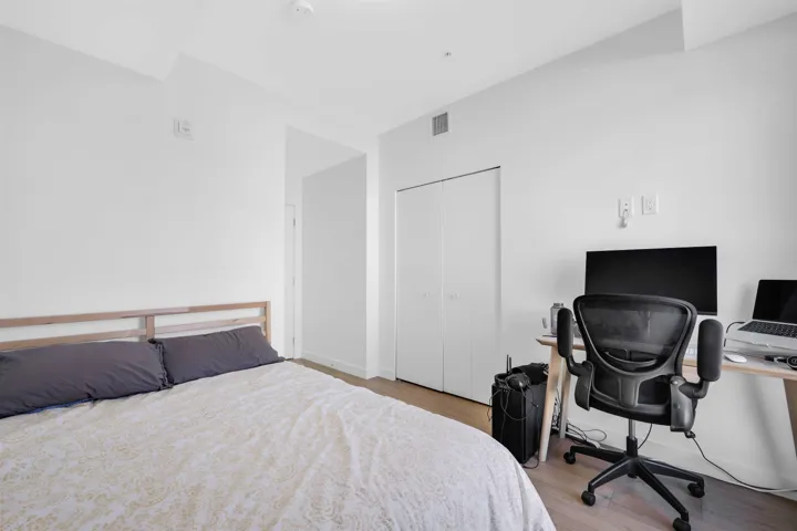 Bedroom with a closet, wood finished floors, and an office area
