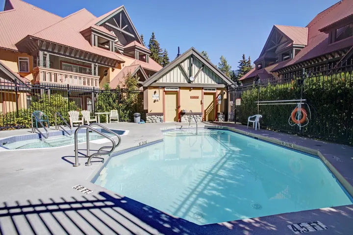 Community pool featuring a patio, an outbuilding, and a community hot tub