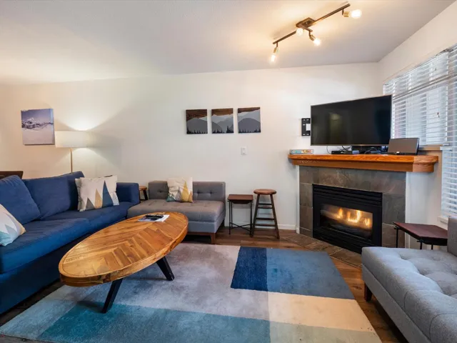 Living area with a tiled fireplace and wood finished floors