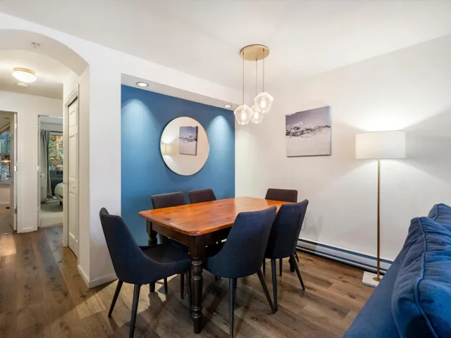 Dining area featuring a baseboard heating unit, baseboards, wood finished floors, and arched walkways