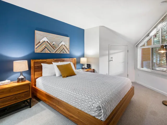 Bedroom with vaulted ceiling, baseboards, and carpet floors