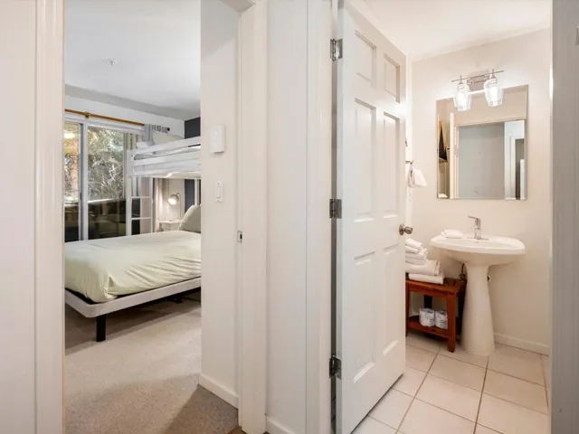 Hall with tile patterned flooring, baseboards, and a sink