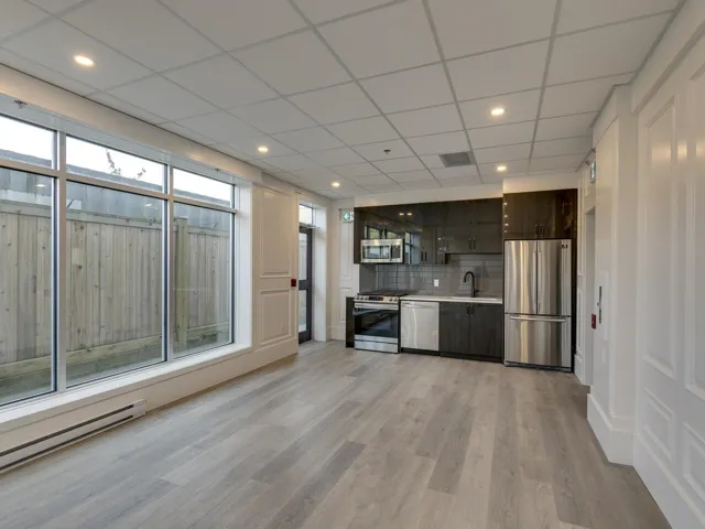Kitchen featuring a sink, modern cabinets, appliances with stainless steel finishes, light countertops, and a baseboard radiator