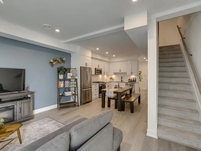 Living area with recessed lighting, light wood-type flooring, baseboards, and stairs
