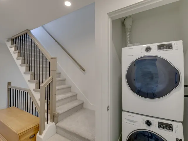 Clothes washing area featuring stacked washer and dryer, laundry area, and recessed lighting
