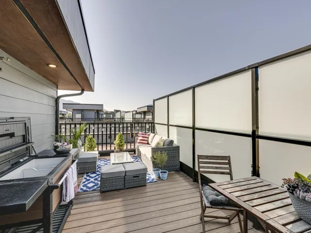 View of wooden balcony with a wooden deck, outdoor lounge area, and outdoor dining area