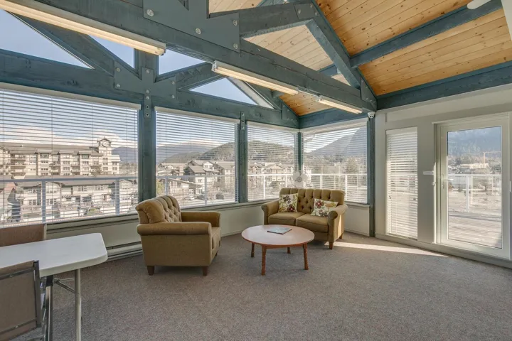 Common area Sunroom with vaulted ceiling with beams.