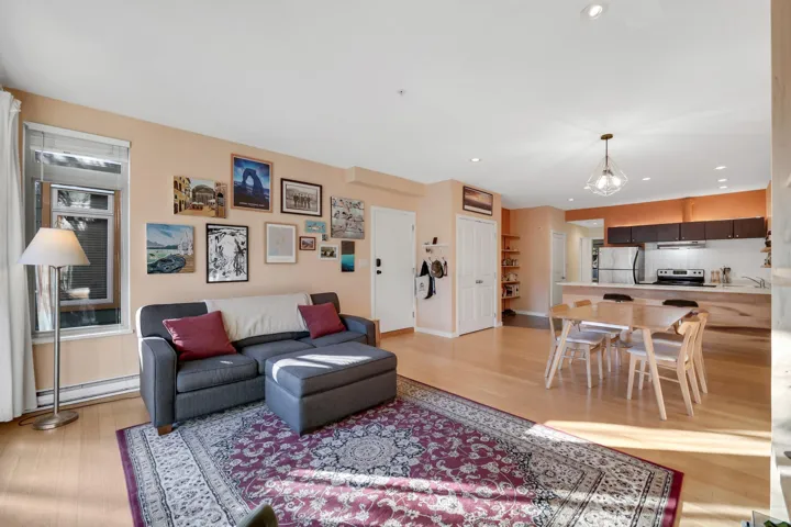 Living area featuring recessed lighting, a baseboard radiator, light wood finished floors, and a chandelier