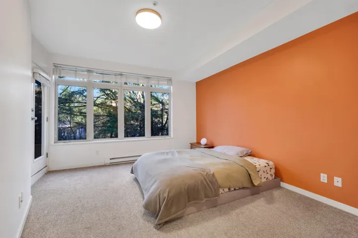 Carpeted bedroom featuring baseboards and a baseboard heating unit