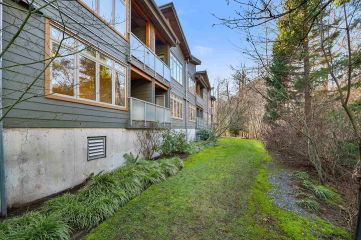 View of grassy yard featuring a balcony