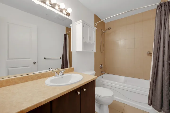 Full bath with vanity, shower / bath combo, and light tile patterned floors