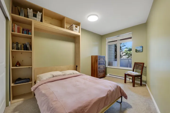Bedroom featuring light carpet and baseboard heating