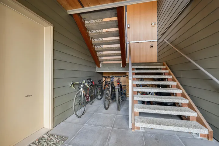 Stairway with wooden walls and tile patterned flooring