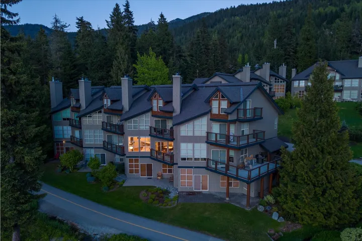 Multi-level residence featuring multiple private balconies, extensive window placements, and a pitched roofline