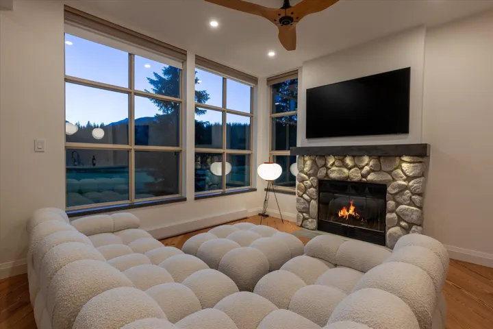 Stone fireplace with a dark wood-finish mantel and integrated lighting