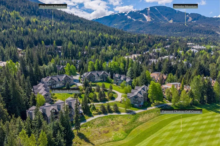 Aerial perspective showcasing multiple residential buildings nestled within a dense forested area, bordered by a manicured golf course