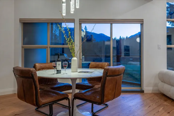 Wood-finish flooring, white walls, and a modern chandelier