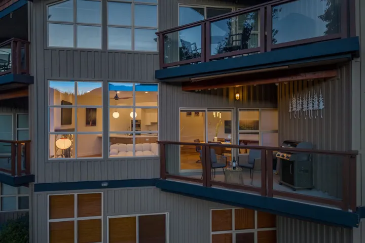 Multiple balconies featuring glass railings and wood-finish accents