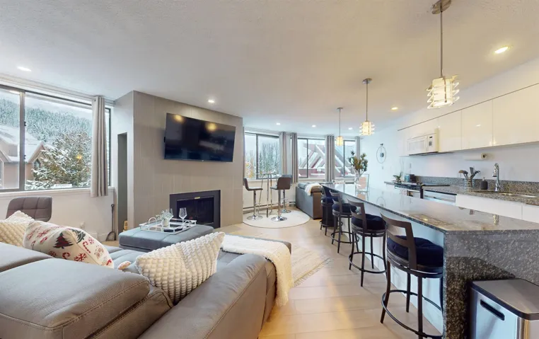 Living room with a large fireplace, light wood-type flooring, recessed lighting, and a textured ceiling