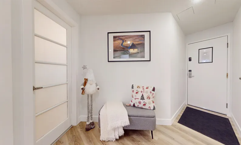 Foyer entrance with light wood finished floors and baseboards