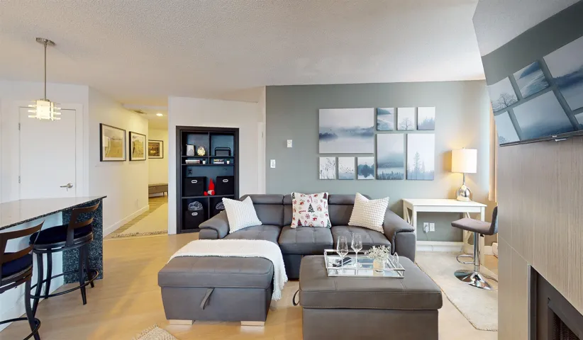 Living area with light wood finished floors, a textured ceiling, and a fireplace