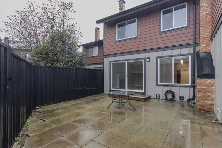 Back of property with a patio area, a chimney, and a fenced backyard