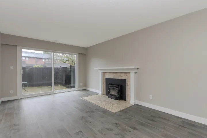 Unfurnished living room featuring wood finished floors and a wood stove
