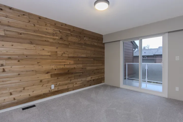 Empty room featuring wood walls and carpet