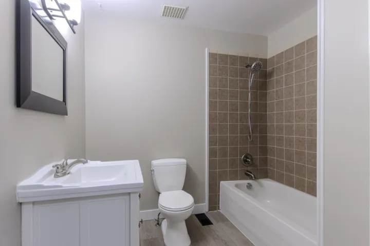 Full bathroom featuring bathtub / shower combination, vanity, and light wood-type flooring