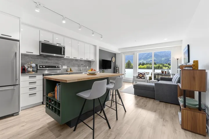 Two tone kitchen featuring a breakfast bar area, stainless steel appliances, wooden counters, a kitchen island, and light wood-type flooring