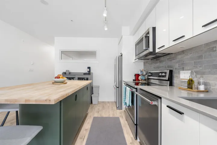 Dual tone kitchen with stainless steel appliances, modern cabinets, a breakfast bar, dual tone cabinetry, and light wood-type flooring