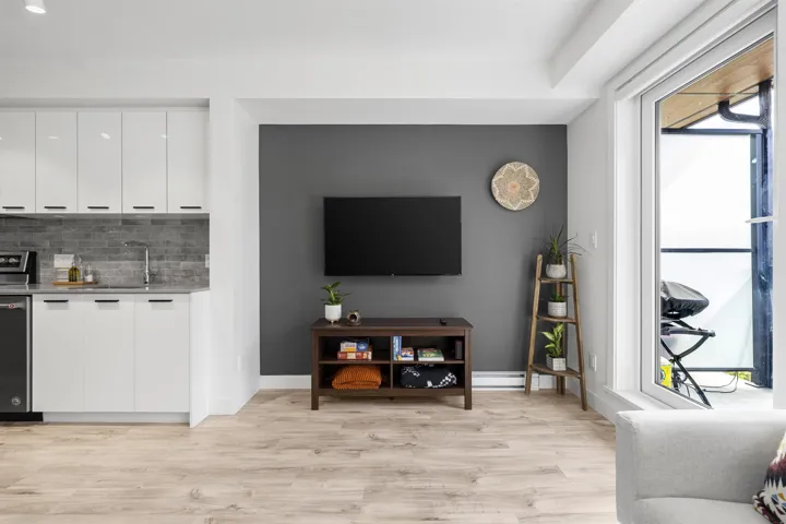 Living room with light wood-style floors and wet bar