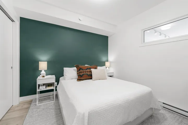 Bedroom with a baseboard heating unit, a closet, and wood finished floors
